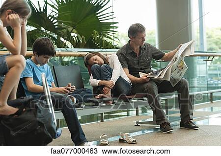 Stock Image - Family waiting in airport terminal. Fotosearch
