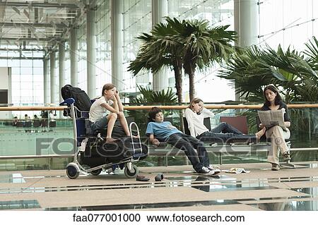 Stock Image - Family waiting in airport terminal. Fotosearch
