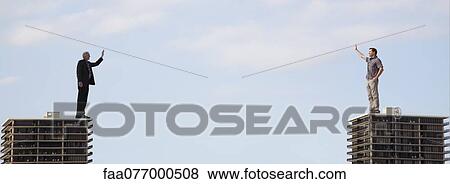 Stock Photo - Giant men standing on top of high rise buildings, waving at each other. Fotosearch