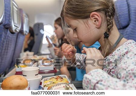 Stock Image - Girl about to eat airline meal. Fotosearch