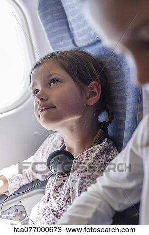 Stock Image - Girl daydreaming on airplane. Fotosearch