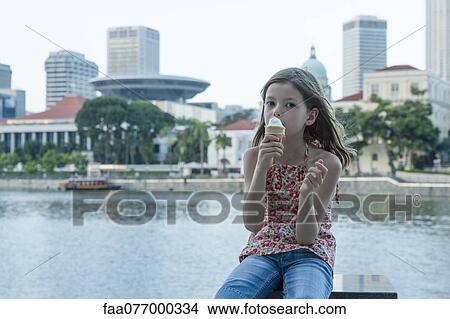 Girl eating ice cream cone by river View Large Photo Image Picture - Girl eating ice cream cone by river. Fotosearch