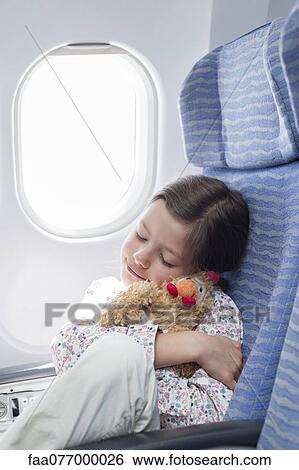 Girl embracing stuffed toy on airplane View Large Photo Image Stock Photograph - Girl embracing stuffed toy on airplane. Fotosearch