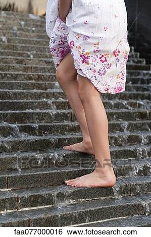 Girl going up steps with water cascading down, low section View Large Photo Image Stock Photograph - Girl going up steps with water cascading down, low section. Fotosearch