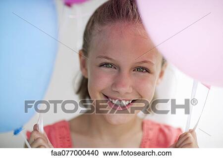 Stock Image - Girl holding balloons, portrait. Fotosearch