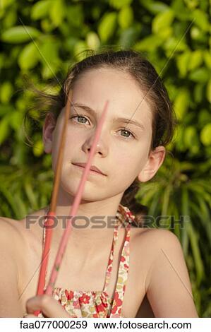 Girl holding chopsticks View Large Photo Image Stock Photo - Girl holding chopsticks. Fotosearch