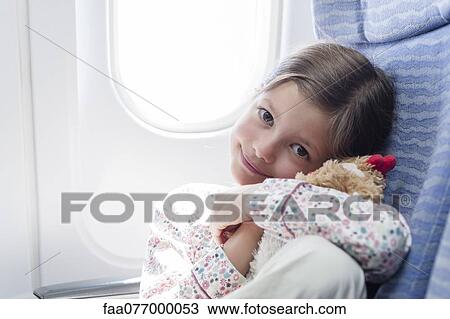 Girl holding stuffed toy on airplane, portrait View Large Photo Image Stock Image - Girl holding stuffed toy on airplane, portrait. Fotosearch
