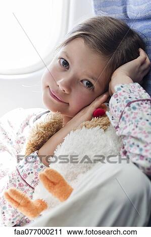 Girl holding stuffed toy on airplane, portrait View Large Photo Image Stock Image - Girl holding stuffed toy on airplane, portrait. Fotosearch