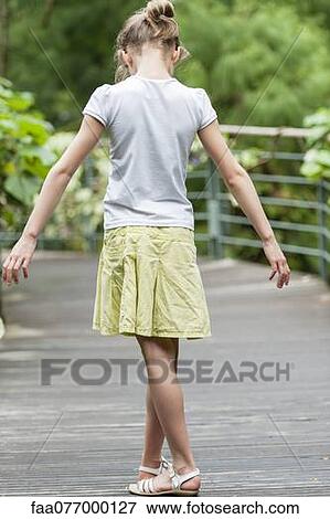Stock Photo - Girl lost in thought, looking down at her feet. Fotosearch