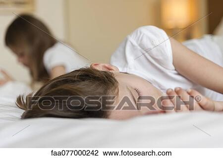 Stock Image - Girl napping on bed. Fotosearch