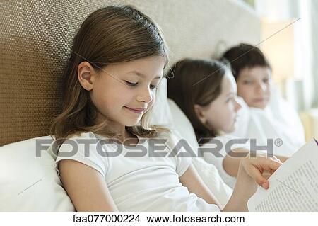 Girl reading book in bed View Large Photo Image Picture - Girl reading book in bed. Fotosearch