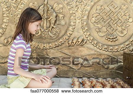 Girl sitting on floor in front of prayer candles View Large Photo Image Stock Photo - Girl sitting on floor in front of prayer candles. Fotosearch