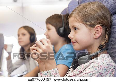 Girl using remote control to change channels on airplane View Large Photo Image Stock Photo - Girl using remote control to change channels on airplane. Fotosearch