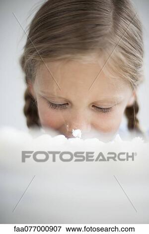 Stock Photo - Girl with cake frosting on her nose. Fotosearch