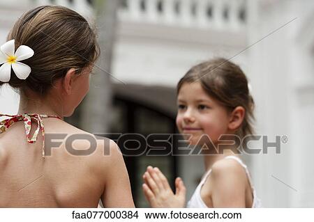 Girl with frangipani flower in hair View Large Photo Image Picture - Girl with frangipani flower in hair. Fotosearch