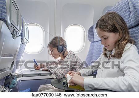 Stock Photograph - Girls on airplane. Fotosearch