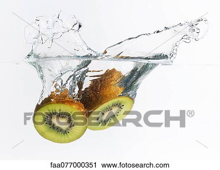 Stock Image - Kiwi halves splashing into water. Fotosearch