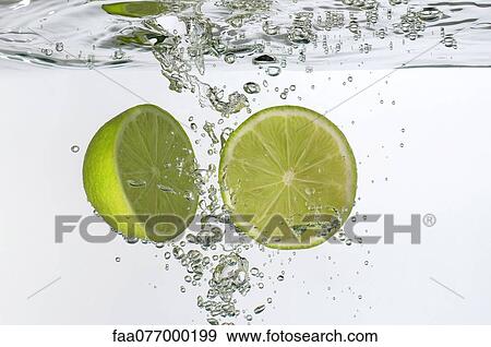 Stock Photo - Lime halves submerged in water. Fotosearch