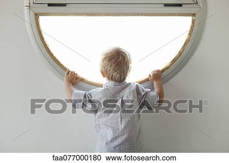 Little boy looking through window, rear view View Large Photo Image Stock Image - Little boy looking through window, rear view. Fotosearch