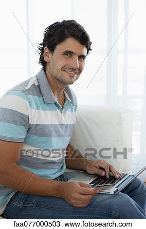 Man holding credit card while using laptop computer, portrait View Large Photo Image Stock Image - Man holding credit card while using laptop computer, portrait. Fotosearch