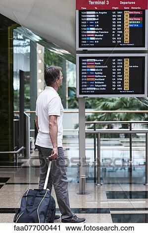 Man looking at arrival departure board in airport View Large Photo Image Stock Image - Man looking at arrival departure board in airport. Fotosearch