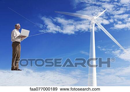 Stock Photo - Man standing on cloud, using laptop computer powered by wind turbine. Fotosearch