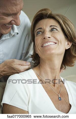 Stock Photography - Mature man giving woman necklace. Fotosearch