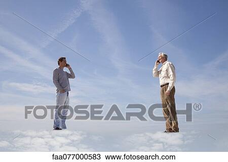 Stock Image - Men standing on clouds, using cell phones. Fotosearch