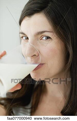 Mid-adult woman drinking glass of milk View Large Photo Image Stock Image - Mid-adult woman drinking glass of milk. Fotosearch