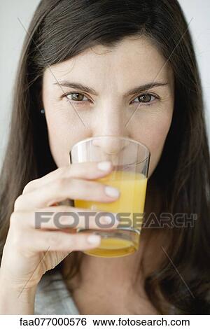 Mid-adult woman drinking orange juice View Large Photo Image Stock Photograph - Mid-adult woman drinking orange juice. Fotosearch