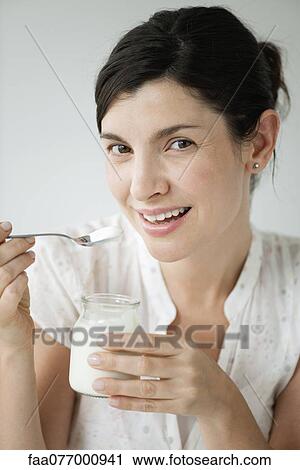 Mid-adult woman eating yogurt, portrait View Large Photo Image Stock Image - Mid-adult woman eating yogurt, portrait. Fotosearch