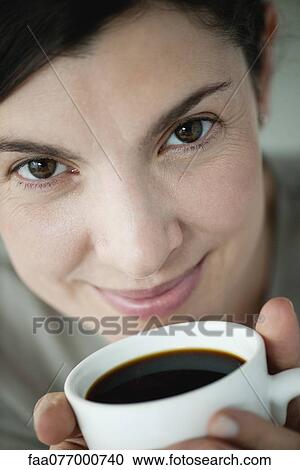 Mid-adult woman holding cup of coffee View Large Photo Image Stock Image - Mid-adult woman holding cup of coffee. Fotosearch