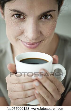 Stock Photo - Mid-adult woman holding cup of coffee. Fotosearch