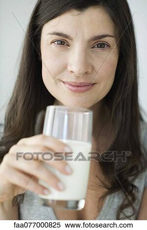 Stock Photography - Mid-adult woman holding glass of milk. Fotosearch