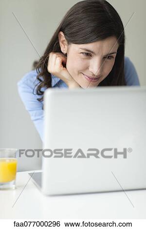 Stock Photograph - Mid-adult woman using laptop computer. Fotosearch
