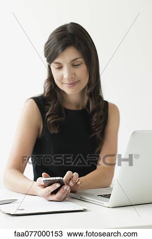 Stock Image - Mid-adult woman using smartphone. Fotosearch
