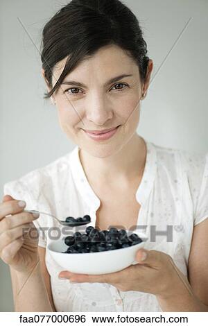 Stock Photograph - Mid-adult woman with bowl of blueberries. Fotosearch