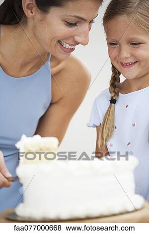 Stock Photo - Mother and daughter cutting cake. Fotosearch