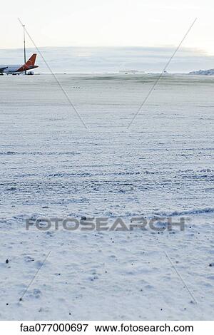 Stock Photo - Plane on snow-covered tarmac at Keflavic International Airport, Keflavik, Iceland. Fotosearch
