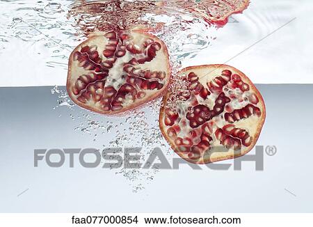 Pomegranate halves submerged in water View Large Photo Image Picture - Pomegranate halves submerged in water. Fotosearch