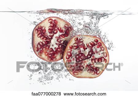 Stock Photo - Pomegranate halves submerged in water. Fotosearch