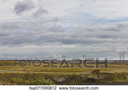 Stock Image - Power lines running through rural field. Fotosearch