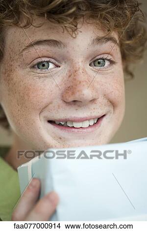 Preteen boy holding gift, portrait View Large Photo Image Picture - Preteen boy holding gift, portrait. Fotosearch
