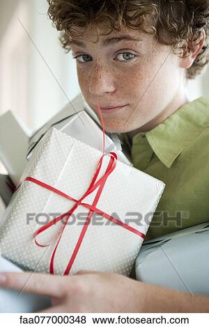 Stock Photo - Preteen boy holding gifts. Fotosearch