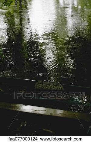 Picture - Raindrops and reflected light on surface of water. Fotosearch