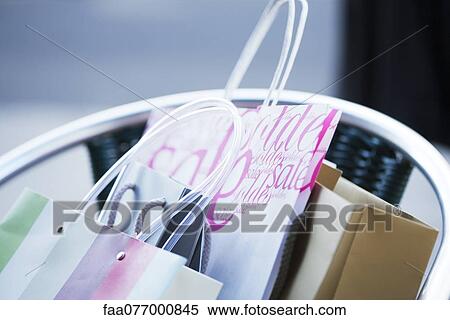 Stock Photography - Shopping bags in chair, cropped. Fotosearch