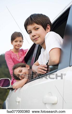 Siblings leaning out of car window, smiling, portrait View Large Photo Image Stock Image - Siblings leaning out of car window, smiling, portrait. Fotosearch