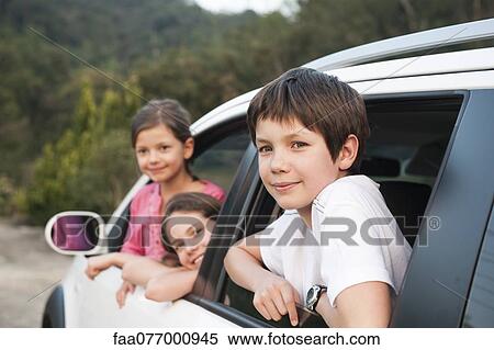 Stock Photography - Siblings leaning out of car window, smiling, portrait. Fotosearch