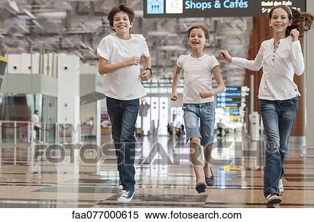 Stock Photography - Siblings running in airport. Fotosearch