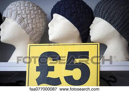 Stock Photo - Sign advertising price of knit hats in store. Fotosearch